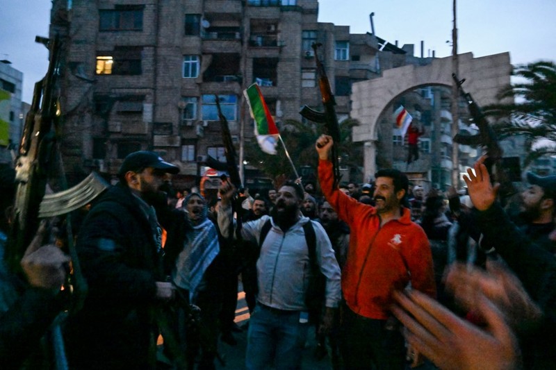 Orang- orang berkumpul di alun-alun utama Damaskus sambil melambaikan tangan dan meneriakkan 'Kebebasan' dari pemerintahan keluarga Assad yang telah berkuasa sekitar 50 tahun. (Photo by LOUAI BESHARA / AFP) Orang- orang berkumpul di alun-alun utama Damaskus sambil melambaikan tangan dan meneriakkan 'Kebebasan' dari pemerintahan keluarga Assad yang telah berkuasa sekitar 50 tahun. (Photo by LOUAI BESHARA / AFP)
