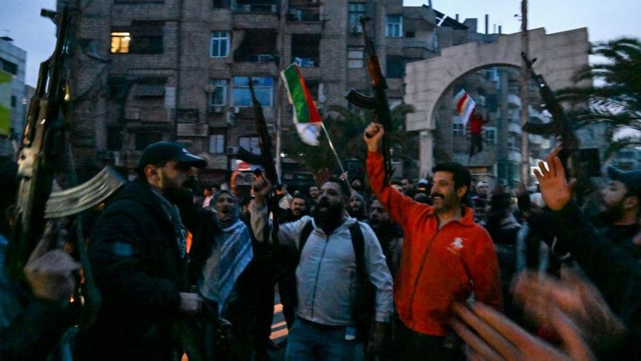 Orang- orang berkumpul di alun-alun utama Damaskus sambil melambaikan tangan dan meneriakkan 'Kebebasan' dari pemerintahan keluarga Assad yang telah berkuasa sekitar 50 tahun. (Photo by LOUAI BESHARA / AFP)