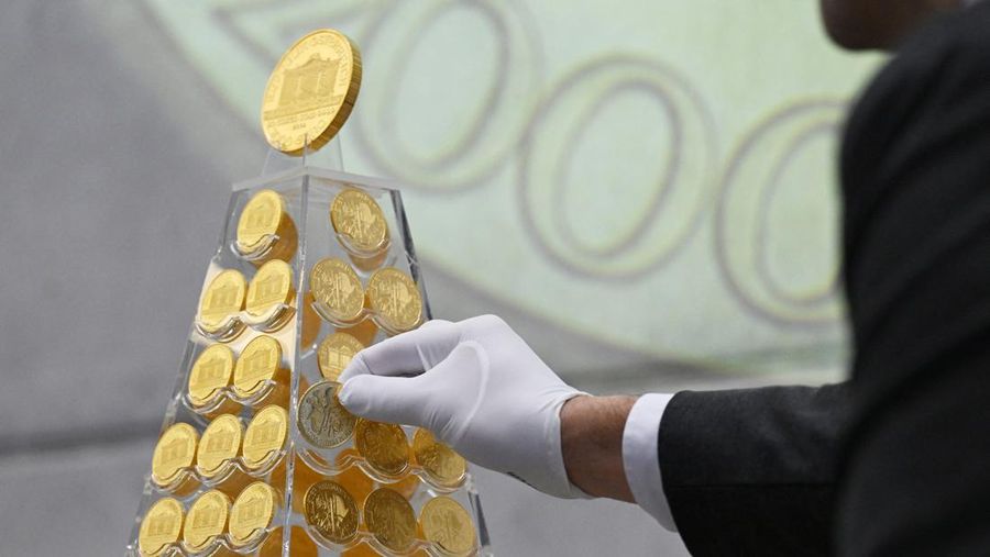 Benjamin Summa, karyawan perusahaan perdagangan emas Munich, meletakkan koin emas di 'Pohon Natal Emas' dengan nilai saat ini sekitar 5,3 juta euro di Munich, Jerman, Selasa, 3 Desember 2024. (Sven Hoppe/dpa/dpa via AP)