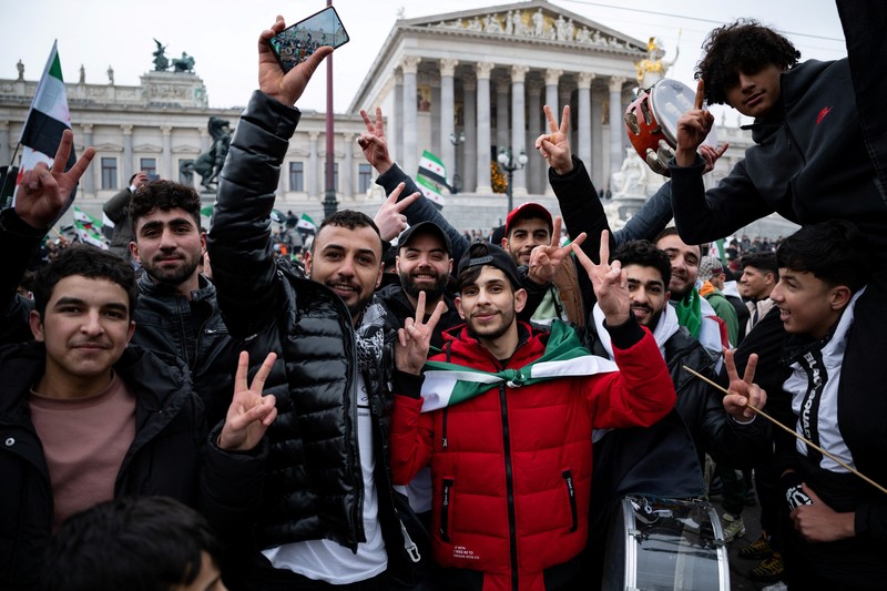 Orang-orang memegang bendera oposisi Suriah saat merayakan, setelah komando tentara Suriah memberi tahu para perwira pada hari Minggu bahwa pemerintahan otoriter Presiden Bashar al-Assad selama 24 tahun telah berakhir, seorang perwira Suriah yang diberitahu tentang tindakan tersebut mengatakan kepada Reuters, menyusul serangan pemberontak cepat yang mengejutkan dunia, di Aleppo, Suriah 8 Desember 2024. Orang-orang memegang bendera oposisi Suriah saat merayakan, setelah komando tentara Suriah memberi tahu para perwira pada hari Minggu bahwa pemerintahan otoriter Presiden Bashar al-Assad selama 24 tahun telah berakhir, seorang perwira Suriah yang diberitahu tentang tindakan tersebut mengatakan kepada Reuters, menyusul serangan pemberontak cepat yang mengejutkan dunia, di Aleppo, Suriah 8 Desember 2024. (REUTERS/Karam al-Masri)