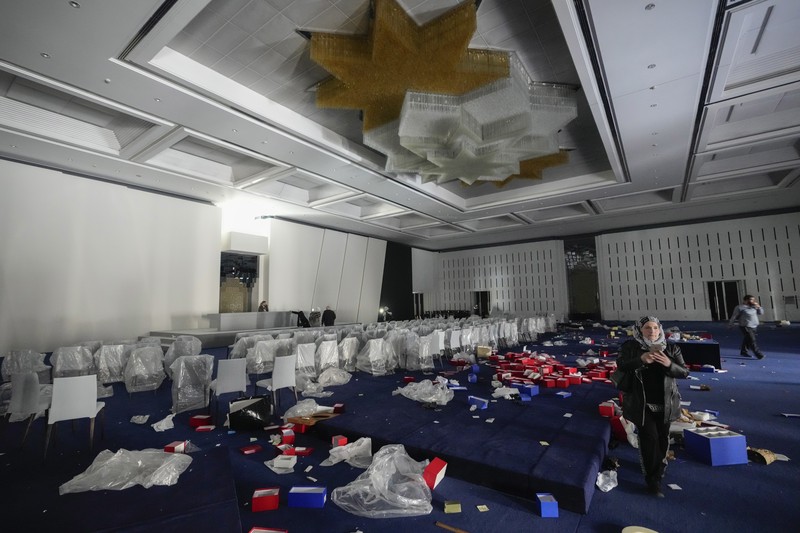 Orang-orang berjalan di ruang konferensi di dalam istana kepresidenan Presiden Suriah Bashar Assad di Damaskus, Suriah, Minggu, 8 Desember 2024. (AP Photo/Hussein Malla)