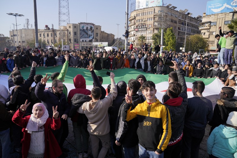 Orang-orang memegang bendera oposisi Suriah saat merayakan, setelah komando tentara Suriah memberi tahu para perwira pada hari Minggu bahwa pemerintahan otoriter Presiden Bashar al-Assad selama 24 tahun telah berakhir, seorang perwira Suriah yang diberitahu tentang tindakan tersebut mengatakan kepada Reuters, menyusul serangan pemberontak cepat yang mengejutkan dunia, di Aleppo, Suriah 8 Desember 2024. Orang-orang memegang bendera oposisi Suriah saat merayakan, setelah komando tentara Suriah memberi tahu para perwira pada hari Minggu bahwa pemerintahan otoriter Presiden Bashar al-Assad selama 24 tahun telah berakhir, seorang perwira Suriah yang diberitahu tentang tindakan tersebut mengatakan kepada Reuters, menyusul serangan pemberontak cepat yang mengejutkan dunia, di Aleppo, Suriah 8 Desember 2024. (REUTERS/Karam al-Masri)