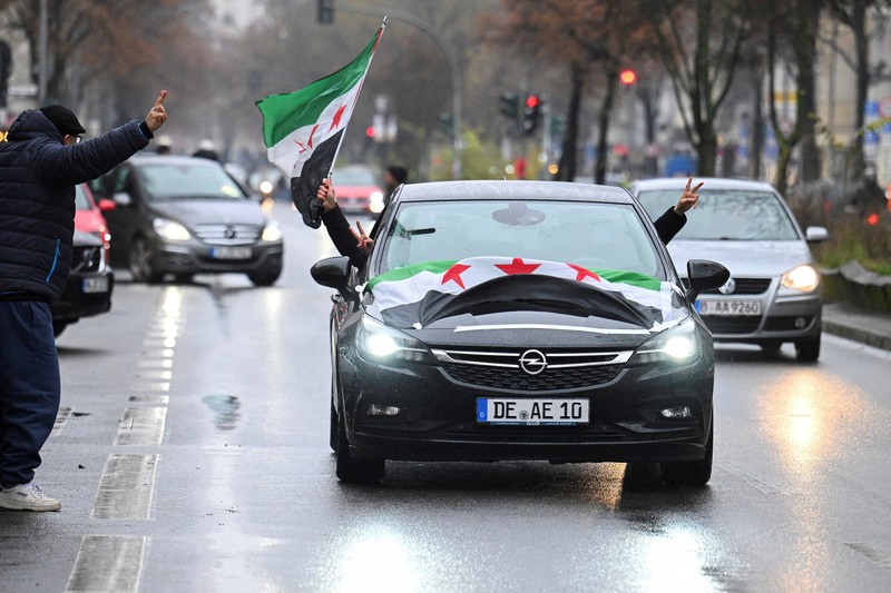 Orang-orang memegang bendera oposisi Suriah saat merayakan, setelah komando tentara Suriah memberi tahu para perwira pada hari Minggu bahwa pemerintahan otoriter Presiden Bashar al-Assad selama 24 tahun telah berakhir, seorang perwira Suriah yang diberitahu tentang tindakan tersebut mengatakan kepada Reuters, menyusul serangan pemberontak cepat yang mengejutkan dunia, di Aleppo, Suriah 8 Desember 2024. Orang-orang memegang bendera oposisi Suriah saat merayakan, setelah komando tentara Suriah memberi tahu para perwira pada hari Minggu bahwa pemerintahan otoriter Presiden Bashar al-Assad selama 24 tahun telah berakhir, seorang perwira Suriah yang diberitahu tentang tindakan tersebut mengatakan kepada Reuters, menyusul serangan pemberontak cepat yang mengejutkan dunia, di Aleppo, Suriah 8 Desember 2024. (REUTERS/Karam al-Masri)