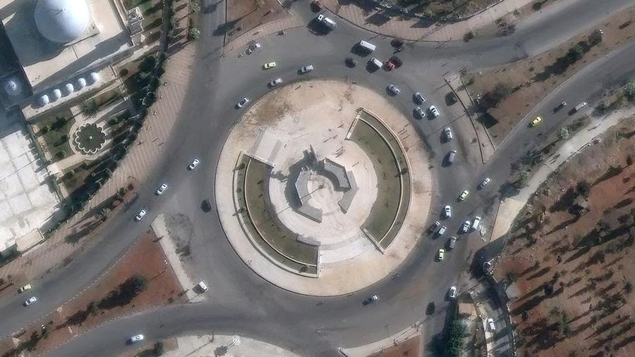 Orang-orang berdiri di dekat patung mantan presiden Suriah Hafez al-Assad yang rusak setelah pemberontak Suriah mengumumkan bahwa mereka telah menggulingkan Presiden Bashar al-Assad, di Qamishli, Suriah, 8 Desember 2024. (REUTERS/Orhan Qereman)