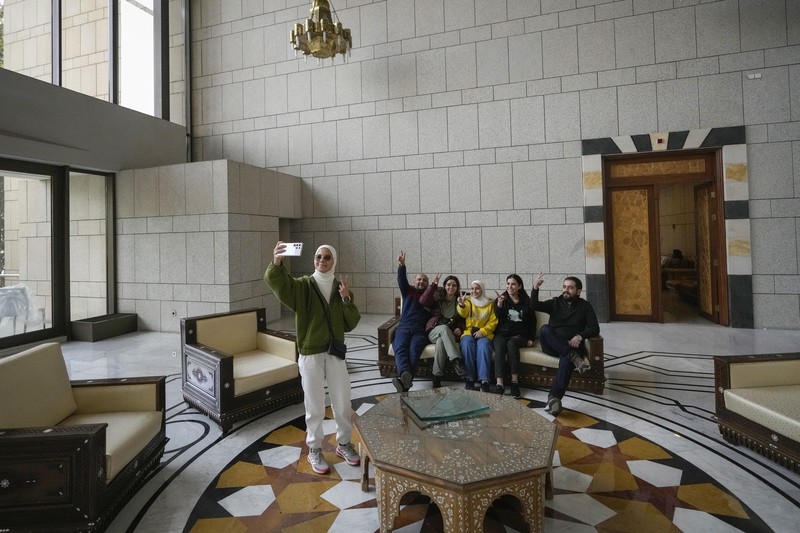 Orang-orang berjalan di ruang konferensi di dalam istana kepresidenan Presiden Suriah Bashar Assad di Damaskus, Suriah, Minggu, 8 Desember 2024. (AP Photo/Hussein Malla)