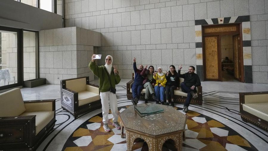 Orang-orang berjalan di ruang konferensi di dalam istana kepresidenan Presiden Suriah Bashar Assad di Damaskus, Suriah, Minggu, 8 Desember 2024. (AP Photo/Hussein Malla)