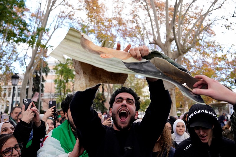 Orang-orang memegang bendera oposisi Suriah saat merayakan, setelah komando tentara Suriah memberi tahu para perwira pada hari Minggu bahwa pemerintahan otoriter Presiden Bashar al-Assad selama 24 tahun telah berakhir, seorang perwira Suriah yang diberitahu tentang tindakan tersebut mengatakan kepada Reuters, menyusul serangan pemberontak cepat yang mengejutkan dunia, di Aleppo, Suriah 8 Desember 2024. (REUTERS/Karam al-Masri)
