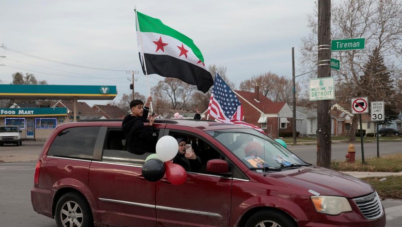 Orang-orang memegang bendera oposisi Suriah saat merayakan, setelah komando tentara Suriah memberi tahu para perwira pada hari Minggu bahwa pemerintahan otoriter Presiden Bashar al-Assad selama 24 tahun telah berakhir, seorang perwira Suriah yang diberitahu tentang tindakan tersebut mengatakan kepada Reuters, menyusul serangan pemberontak cepat yang mengejutkan dunia, di Aleppo, Suriah 8 Desember 2024. (REUTERS/Karam al-Masri)