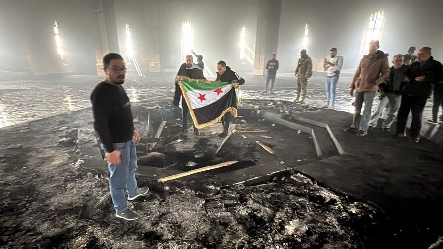 Kombinasi visual yang dibuat pada (11/12/2024) ini menunjukkan gambar (atas) yang diambil pada hari yang sama dari pejuang pemberontak yang berdiri dengan bendera oposisi di makam mendiang presiden Suriah Hafez al-Assad yang terbakar di makamnya di desa leluhur keluarga Qardaha di provinsi Latakia barat, setelah diserbu oleh faksi anti-Assad dan dibakar dan gambar arsip lain yang dirilis oleh Kantor Berita Arab Suriah (SANA) pada (16/11/2011) dari warga Suriah yang mengunjungi makam yang sama untuk memperingati ulang tahun 