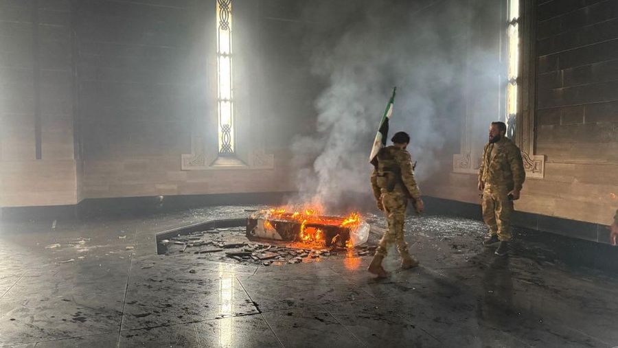 Kombinasi visual yang dibuat pada (11/12/2024) ini menunjukkan gambar (atas) yang diambil pada hari yang sama dari pejuang pemberontak yang berdiri dengan bendera oposisi di makam mendiang presiden Suriah Hafez al-Assad yang terbakar di makamnya di desa leluhur keluarga Qardaha di provinsi Latakia barat, setelah diserbu oleh faksi anti-Assad dan dibakar dan gambar arsip lain yang dirilis oleh Kantor Berita Arab Suriah (SANA) pada (16/11/2011) dari warga Suriah yang mengunjungi makam yang sama untuk memperingati ulang tahun 