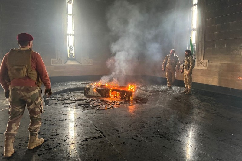Kombinasi visual yang dibuat pada (11/12/2024) ini menunjukkan gambar (atas) yang diambil pada hari yang sama dari pejuang pemberontak yang berdiri dengan bendera oposisi di makam mendiang presiden Suriah Hafez al-Assad yang terbakar di makamnya di desa leluhur keluarga Qardaha di provinsi Latakia barat, setelah diserbu oleh faksi anti-Assad dan dibakar dan gambar arsip lain yang dirilis oleh Kantor Berita Arab Suriah (SANA) pada (16/11/2011) dari warga Suriah yang mengunjungi makam yang sama untuk memperingati ulang tahun Kombinasi visual yang dibuat pada (11/12/2024) ini menunjukkan gambar (atas) yang diambil pada hari yang sama dari pejuang pemberontak yang berdiri dengan bendera oposisi di makam mendiang presiden Suriah Hafez al-Assad yang terbakar di makamnya di desa leluhur keluarga Qardaha di provinsi Latakia barat, setelah diserbu oleh faksi anti-Assad dan dibakar dan gambar arsip lain yang dirilis oleh Kantor Berita Arab Suriah (SANA) pada (16/11/2011) dari warga Suriah yang mengunjungi makam yang sama untuk memperingati ulang tahun