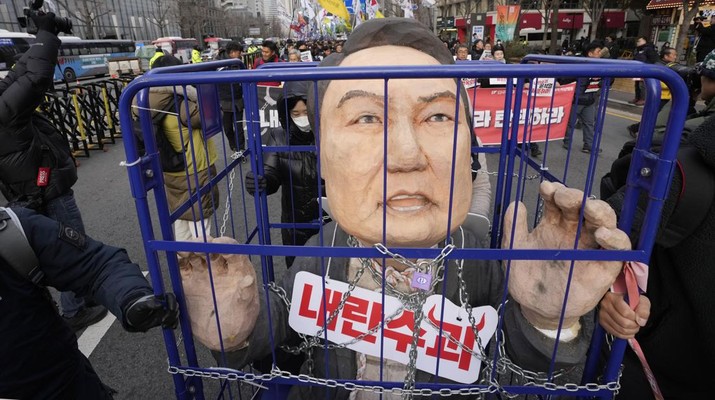 Para pengunjuk rasa membawa karikatur yang menggambarkan Presiden Korea Selatan Yoon Suk Yeol yang dipenjara saat mereka berbaris menuju kantor presiden setelah unjuk rasa menuntut pemakzulannya di Seoul, Korea Selatan, Kamis, 12 Desember 2024. Sebuah tanda bertuliskan