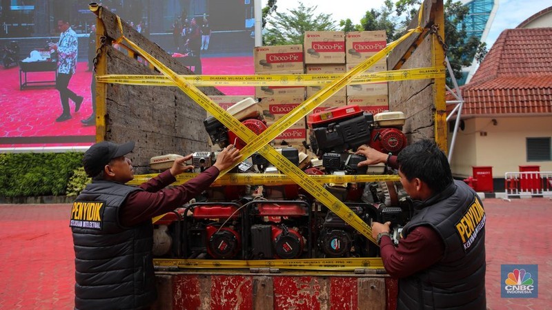 Penyidik memeriksa barang tiruan atau imitasi (KW) saat Ekspose dan Pemusnahan Barang Bukti Hasil Penanganan Pelanggaran Kekayaan Intelektual Tahun 2024 di Lapangan Upacara Kementerian Hukum dan HAM, Jakarta, Kamis (12/12/2024). (վ/Faisal Rahman)