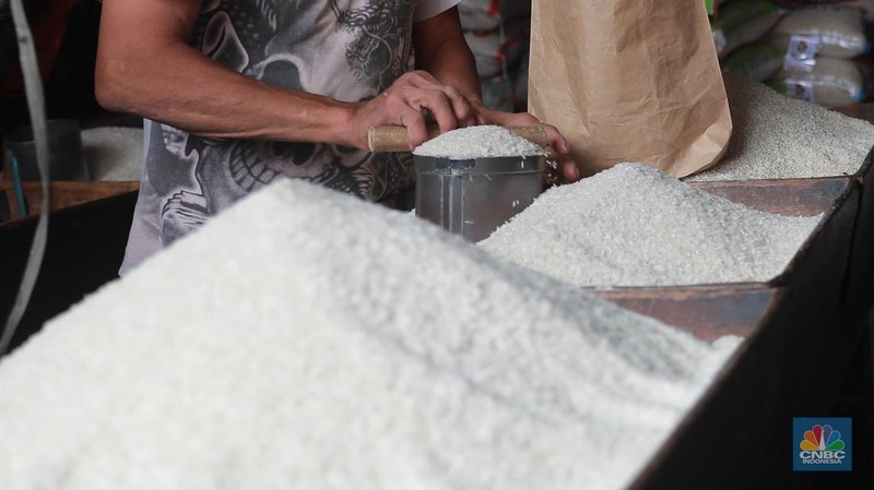 Pekerja menata beras di Kawasan Pasar Kebayoran Lama, Jakarta, Jumat, (13/12/2024). (CNBC Indonesia/Muhammad Sabki)