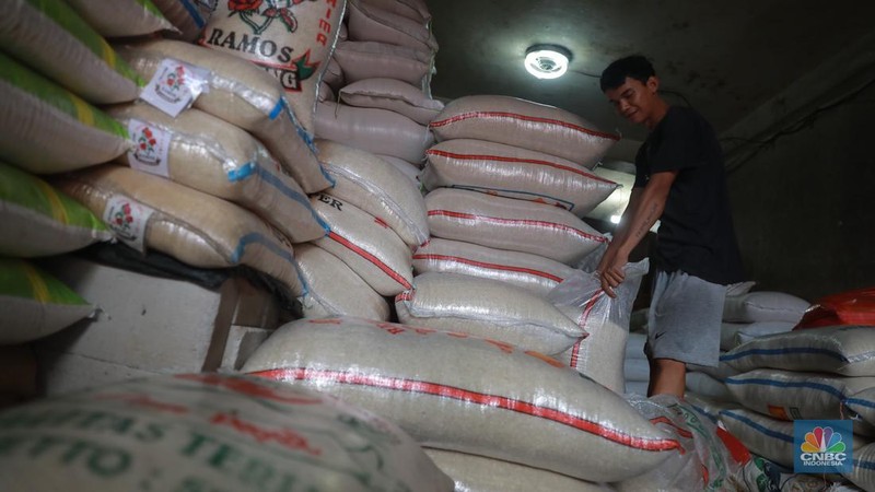 Pekerja menata beras di Kawasan Pasar Kebayoran Lama, Jakarta, Jumat, (13/12/2024). (CNBC Indonesia/Muhammad Sabki)