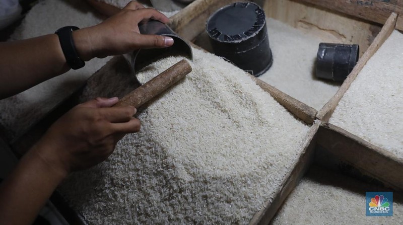 Pekerja menata beras di Kawasan Pasar Kebayoran Lama, Jakarta, Jumat, (13/12/2024). (CNBC Indonesia/Muhammad Sabki)