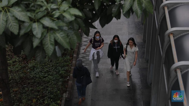 Sejumlah pekerja berjalan pulang di Kawasan Sudirman, Jakarta, Jumat (13/12/2024). (CNBC Indonesia/Muhammad Sabki)