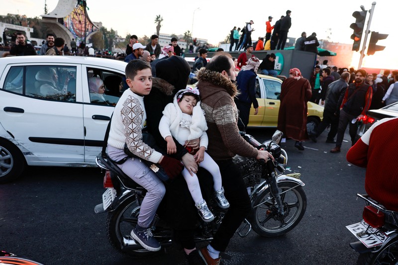 Foto udara menujukkan warga turun ke jalan untuk merayakan para pejuang badan penguasa Suriah yang menggulingkan Bashar Al-Assad di Damasukus, Suriah, Jumat (13/12/2024) waktu setempat. (REUTERS/Yosri Aljamal)