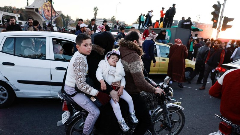 Foto udara menujukkan warga turun ke jalan untuk merayakan para pejuang badan penguasa Suriah yang menggulingkan Bashar Al-Assad di Damasukus, Suriah, Jumat (13/12/2024) waktu setempat. (REUTERS/Yosri Aljamal)