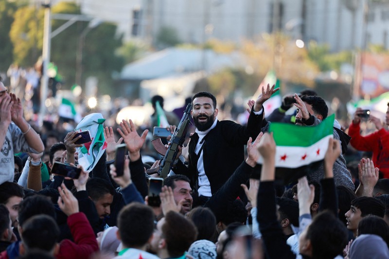 Foto udara menujukkan warga turun ke jalan untuk merayakan para pejuang badan penguasa Suriah yang menggulingkan Bashar Al-Assad di Damasukus, Suriah, Jumat (13/12/2024) waktu setempat. (REUTERS/Yosri Aljamal)