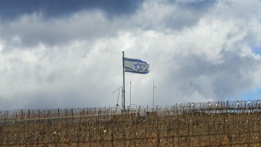 Bendera Israel berkibar di puncak bukit dekat Garis Alfa yang memisahkan Dataran Tinggi Golan yang dikuasai Israel dari Suriah, di kota Majdal Shams, Jumat, 13 Desember 2024. (AP Photo/Matias Delacroix)