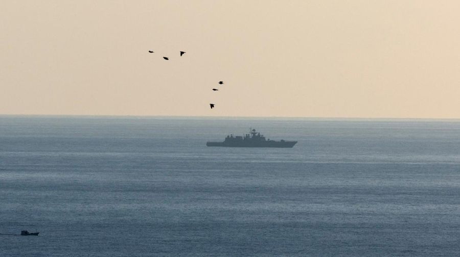Seorang tentara Rusia berpatroli terhadap konvoi militer di pinggir jalan karena kerusakan mesin di salah satu kendaraan saat mereka melakukan perjalanan melalui pangkalan udara Hmeimim di wilayah pesisir Latakia, Suriah, 14 Desember 2024. (REUTERS/Umit Bektas)