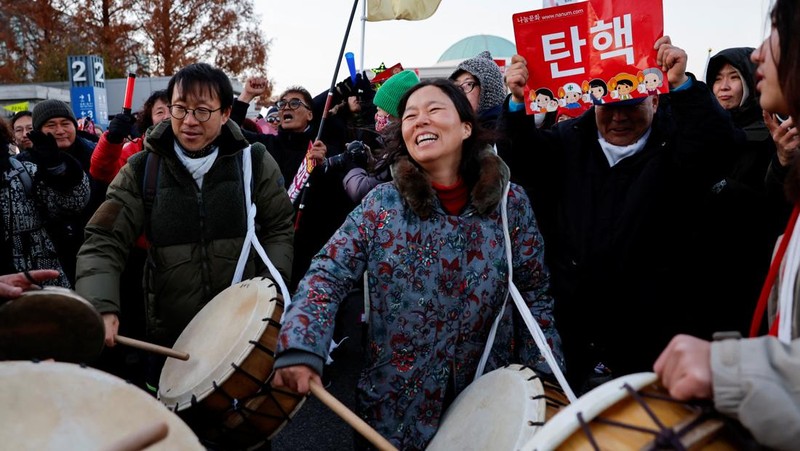 Para pengunjuk rasa berpartisipasi dalam unjuk rasa yang menyerukan pemakzulan Presiden Korea Selatan Yoon Suk Yeol, yang mengumumkan darurat militer, yang dicabut beberapa jam kemudian, di depan Majelis Nasional di Seoul, Korea Selatan, 14 Desember 2024. (Yonhap via REUTERS)