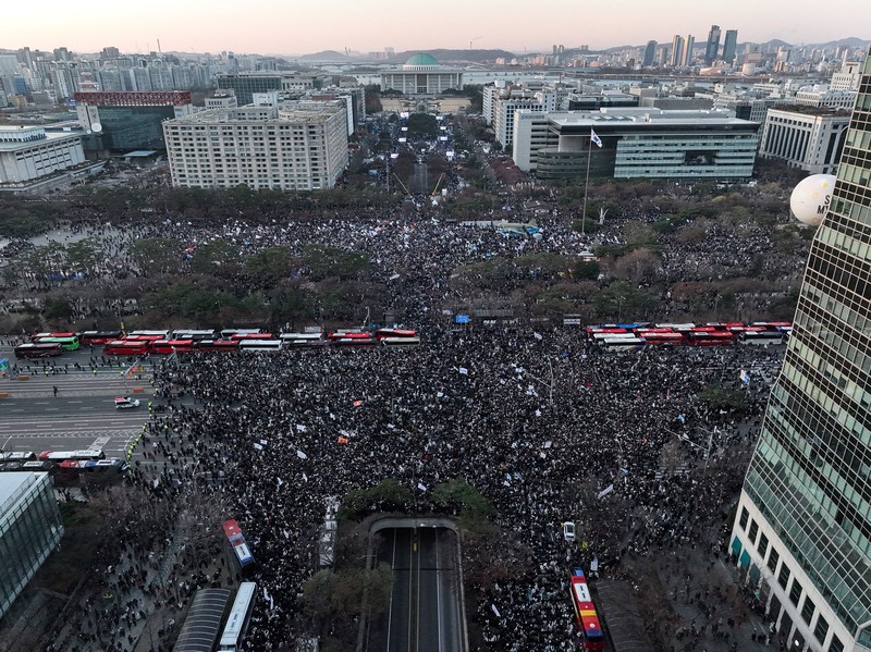 Para pengunjuk rasa berpartisipasi dalam unjuk rasa yang menyerukan pemakzulan Presiden Korea Selatan Yoon Suk Yeol, yang mengumumkan darurat militer, yang dicabut beberapa jam kemudian, di depan Majelis Nasional di Seoul, Korea Selatan, 14 Desember 2024. (Yonhap via REUTERS)