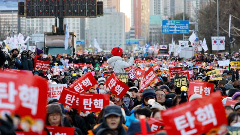 Para pengunjuk rasa berpartisipasi dalam unjuk rasa yang menyerukan pemakzulan Presiden Korea Selatan Yoon Suk Yeol, yang mengumumkan darurat militer, yang dicabut beberapa jam kemudian, di depan Majelis Nasional di Seoul, Korea Selatan, 14 Desember 2024. (Yonhap via REUTERS)