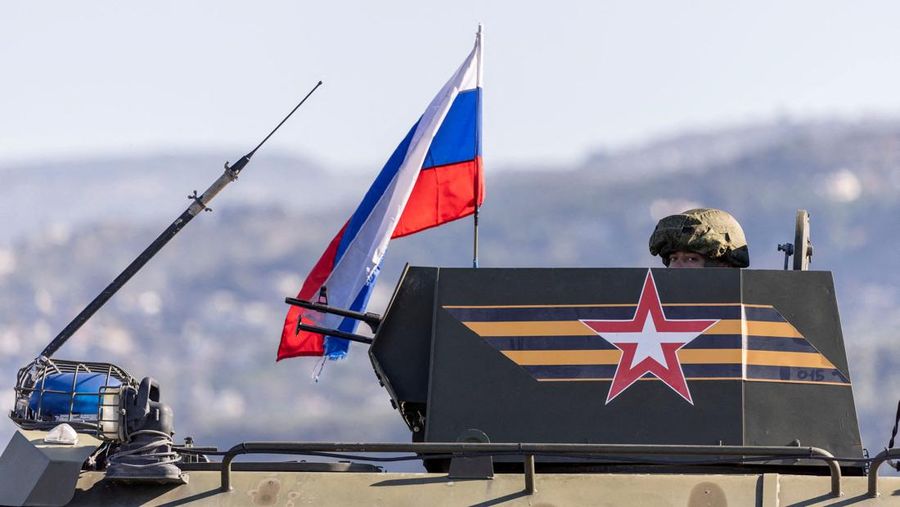 Seorang tentara Rusia mengendarai kendaraan tempur infanteri, bagian dari konvoi militer Rusia menuju pangkalan udara Hmeimim di Latakia, di pantai Suriah, 14 Desember 2024. (REUTERS/Umit Bektas)