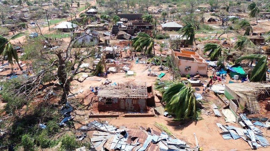 Orang-orang berjalan melewati bangunan yang hancur dan pohon yang tumbang setelah topan Chido melanda Mozambik, di distrik Mecufi, provinsi Cabo Delgado, Mozambik, 16 Desember 2024, dalam tangkapan layar yang diambil dari video drone yang dibagikan. (Unicef Mozambique/Handout via REUTERS)