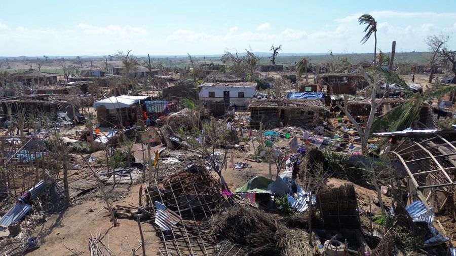 Orang-orang berjalan melewati bangunan yang hancur dan pohon yang tumbang setelah topan Chido melanda Mozambik, di distrik Mecufi, provinsi Cabo Delgado, Mozambik, 16 Desember 2024, dalam tangkapan layar yang diambil dari video drone yang dibagikan. (Unicef Mozambique/Handout via REUTERS)