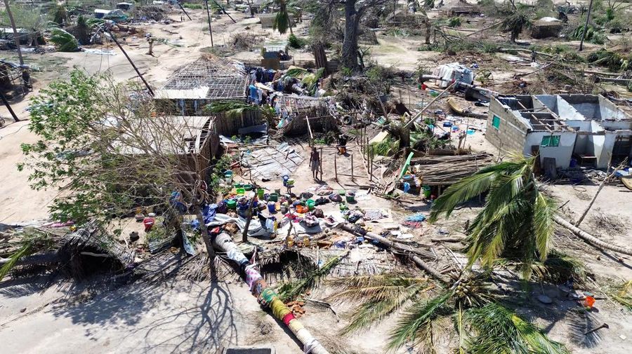 Orang-orang berjalan melewati bangunan yang hancur dan pohon yang tumbang setelah topan Chido melanda Mozambik, di distrik Mecufi, provinsi Cabo Delgado, Mozambik, 16 Desember 2024, dalam tangkapan layar yang diambil dari video drone yang dibagikan. (Unicef Mozambique/Handout via REUTERS)
