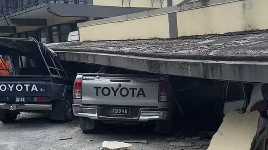 Pasukan keamanan dan penyelamat memeriksa mobil rusak yang terjebak di bawah bangunan yang runtuh di ibu kota Vanuatu, Port Vila, setelah gempa bumi dahsyat melanda dengan magnitudo 7,3M. (Photo by MICHAEL THOMPSON / Facebook account of Michael Thompson / AFP)
