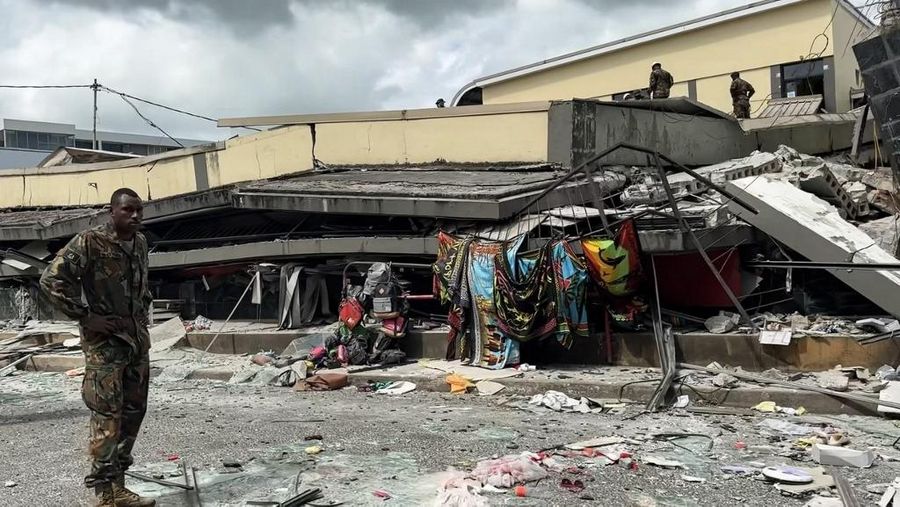 Pasukan keamanan dan penyelamat memeriksa mobil rusak yang terjebak di bawah bangunan yang runtuh di ibu kota Vanuatu, Port Vila, setelah gempa bumi dahsyat melanda dengan magnitudo 7,3M. (Photo by MICHAEL THOMPSON / Facebook account of Michael Thompson / AFP)