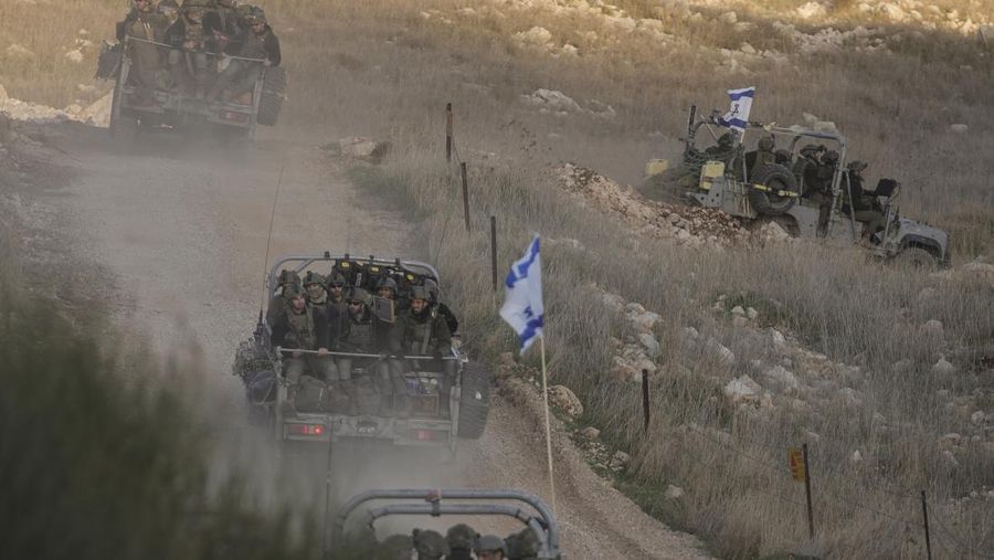 Tentara Israel melintasi pagar keamanan menuju apa yang disebut Garis Alfa yang memisahkan Dataran Tinggi Golan yang dianeksasi Israel dari Suriah, di kota Majdal Shams, Minggu, 15 Desember 2024. (AP Photo/Matias Delacroix)