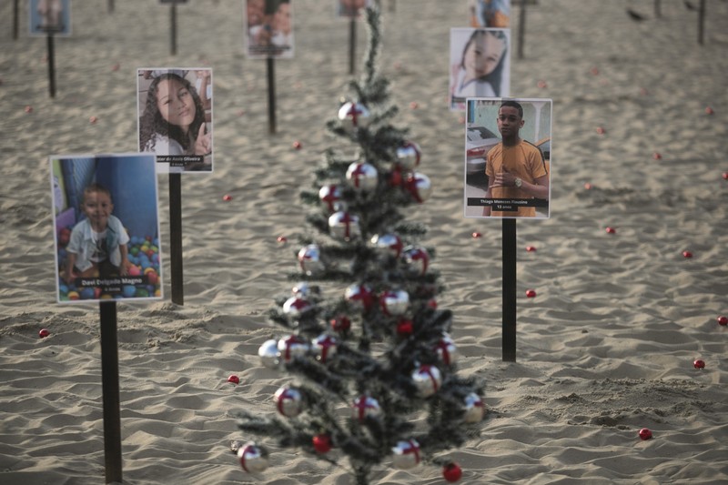 Seorang wanita berlari melewati 48 gambar anak-anak yang ditembak mati selama operasi polisi selama pemerintahan gubernur Rio de Janeiro Claudio Castro, oleh LSM Rio de Paz, di pantai Copacabana di Rio de Janeiro, Brasil, 18 Desember 2024. Seorang wanita berlari melewati 48 gambar anak-anak yang ditembak mati selama operasi polisi selama pemerintahan gubernur Rio de Janeiro Claudio Castro, oleh LSM Rio de Paz, di pantai Copacabana di Rio de Janeiro, Brasil, 18 Desember 2024. (REUTERS/Pilar Olivares)