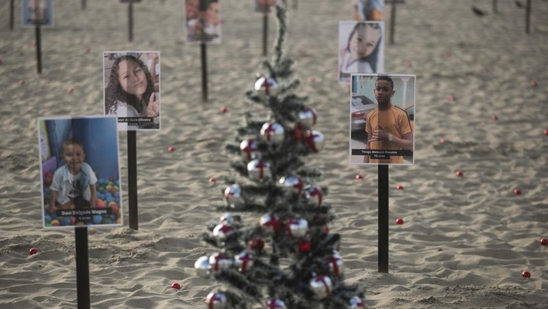 Seorang wanita berlari melewati 48 gambar anak-anak yang ditembak mati selama operasi polisi selama pemerintahan gubernur Rio de Janeiro Claudio Castro, oleh LSM Rio de Paz, di pantai Copacabana di Rio de Janeiro, Brasil, 18 Desember 2024. (REUTERS/Pilar Olivares)