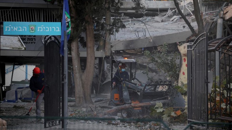 Personel layanan darurat bekerja di dekat lokasi yang rusak setelah proyektil yang ditembakkan dari Yaman dicegat, di Ramat Gan, Israel, 19 Desember 2024. (REUTERS/Stoyan Nenov)