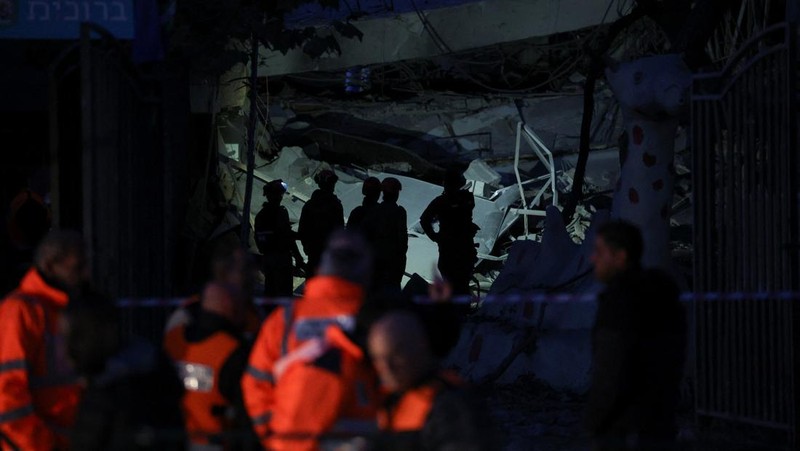 Personel layanan darurat bekerja di dekat lokasi yang rusak setelah proyektil yang ditembakkan dari Yaman dicegat, di Ramat Gan, Israel, 19 Desember 2024. (REUTERS/Stoyan Nenov)