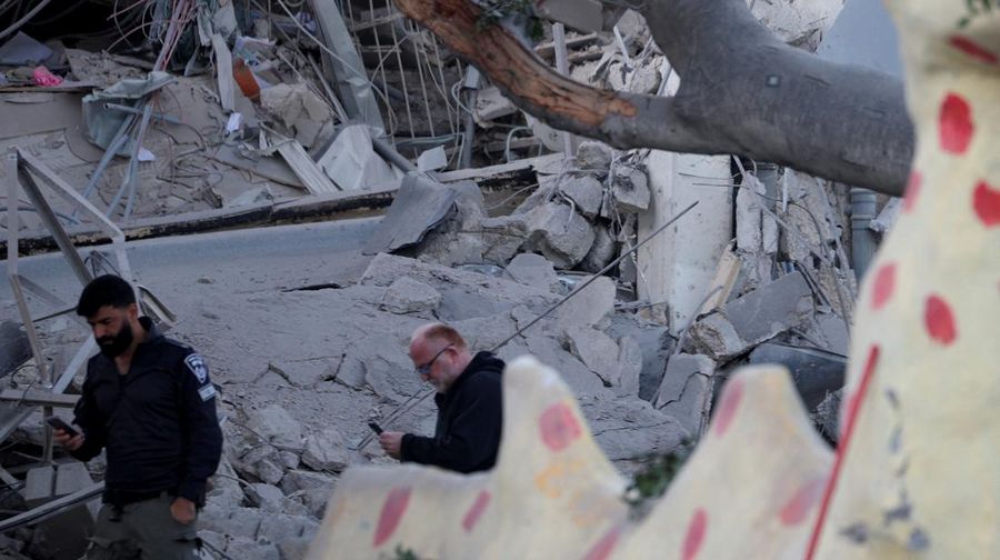 Personel layanan darurat bekerja di dekat lokasi yang rusak setelah proyektil yang ditembakkan dari Yaman dicegat, di Ramat Gan, Israel, 19 Desember 2024. (REUTERS/Stoyan Nenov)
