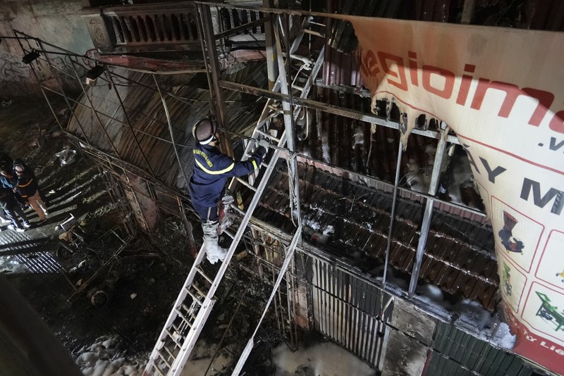 Petugas pemadam kebakaran memeriksa bangunan yang terbakar di Hanoi, Vietnam pada Kamis, 19 Desember 2024. (AP Photo/Hau Dinh)