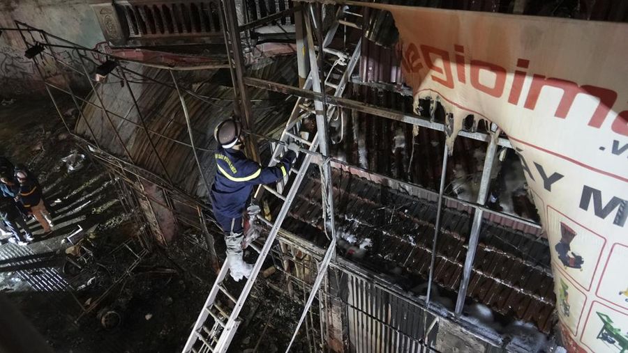 Petugas pemadam kebakaran memeriksa bangunan yang terbakar di Hanoi, Vietnam pada Kamis, 19 Desember 2024. (AP Photo/Hau Dinh)