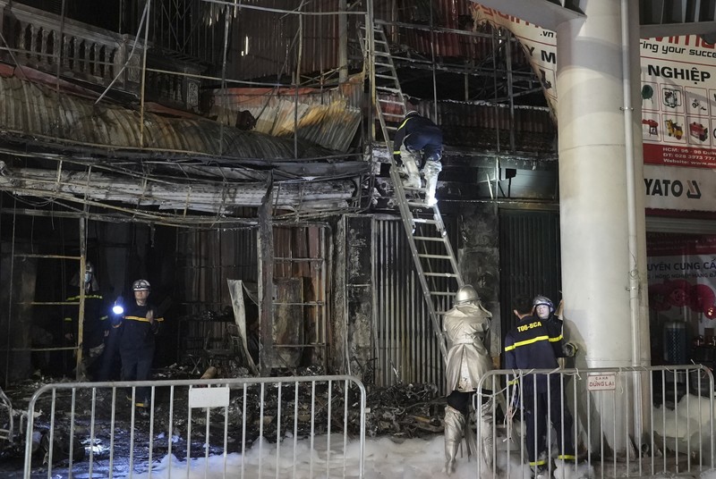 Petugas pemadam kebakaran memeriksa bangunan yang terbakar di Hanoi, Vietnam pada Kamis, 19 Desember 2024. (AP Photo/Hau Dinh)