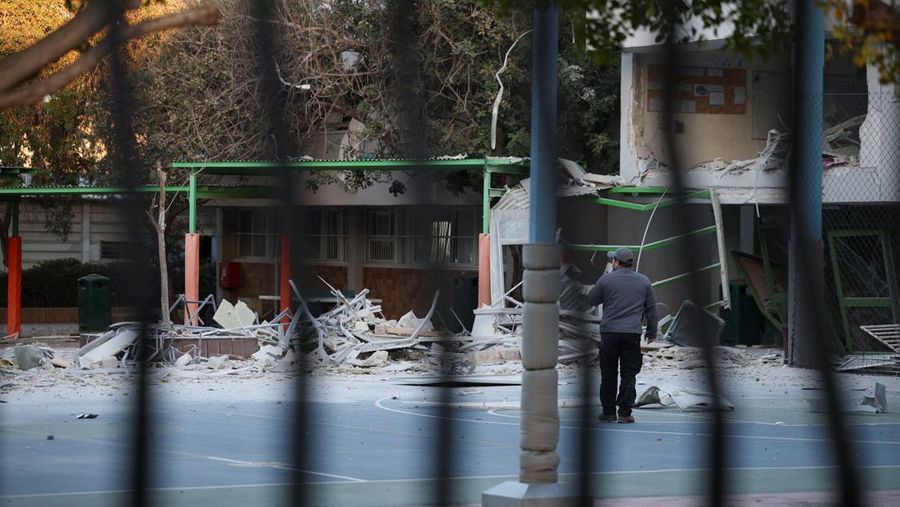 Personel layanan darurat bekerja di dekat lokasi yang rusak setelah proyektil yang ditembakkan dari Yaman dicegat, di Ramat Gan, Israel, 19 Desember 2024. (REUTERS/Stoyan Nenov)