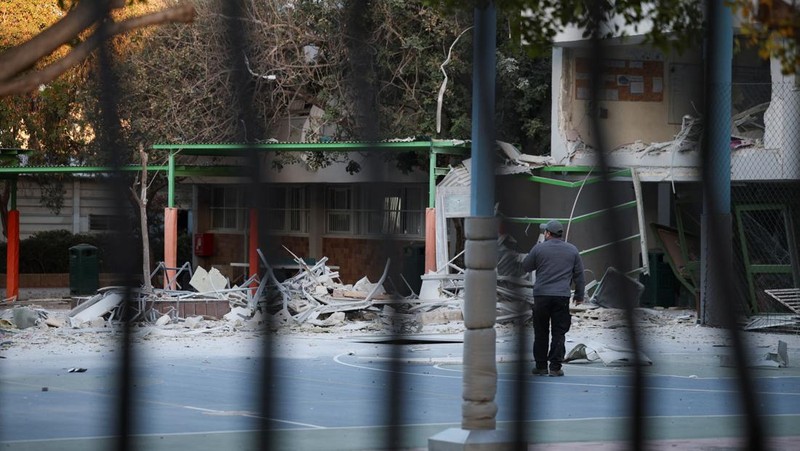 Personel layanan darurat bekerja di dekat lokasi yang rusak setelah proyektil yang ditembakkan dari Yaman dicegat, di Ramat Gan, Israel, 19 Desember 2024. (REUTERS/Stoyan Nenov)