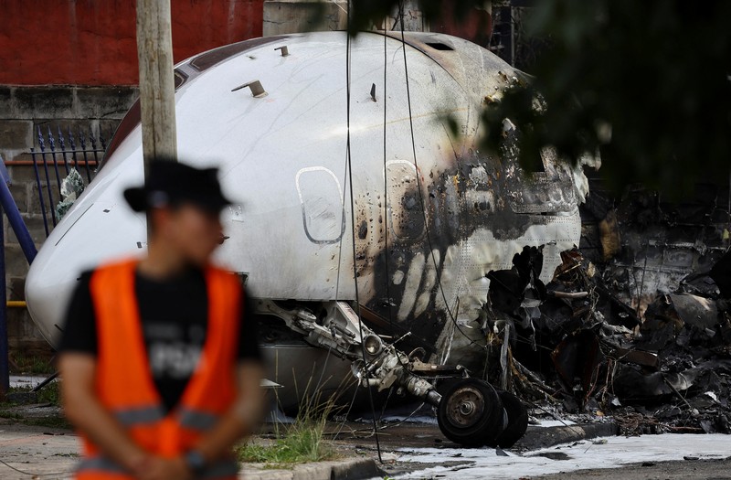 Puing-puing pesawat pribadi tergeletak di samping rumah-rumah setelah jatuh di dekat bandara di San Fernando di pinggiran Buenos Aires, Argentina, Rabu, 18 Desember 2024. (AP Photo/Natacha Pisarenko)