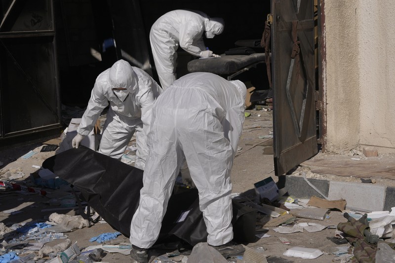 A Syrian civil defense team, known as the White Helmets, inspects a morgue, previously used by pro-government Iranian units, located near the Set Zainab shrine, south of Damascus, Syria, on Wednesday, Dec. 18, 2024 (AP Photo/Hussein Malla)