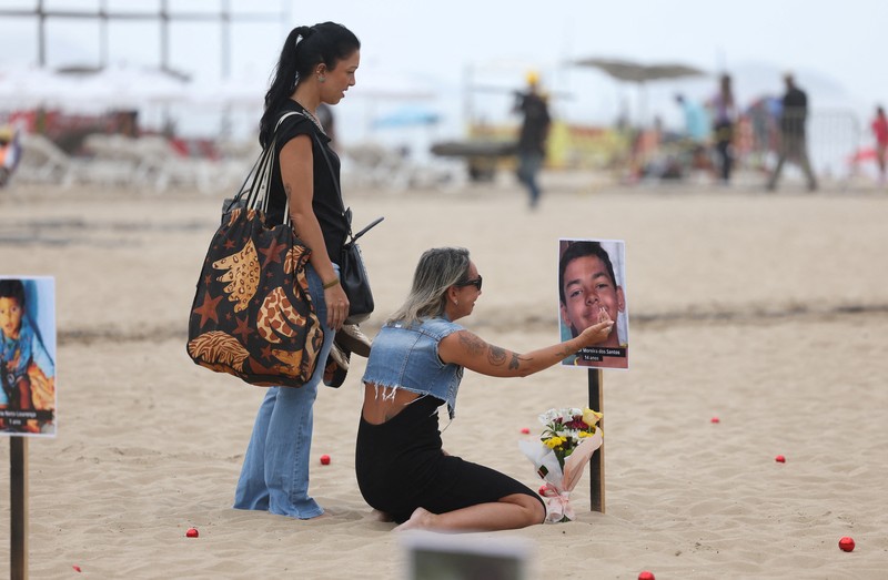 Seorang wanita berlari melewati 48 gambar anak-anak yang ditembak mati selama operasi polisi selama pemerintahan gubernur Rio de Janeiro Claudio Castro, oleh LSM Rio de Paz, di pantai Copacabana di Rio de Janeiro, Brasil, 18 Desember 2024. Seorang wanita berlari melewati 48 gambar anak-anak yang ditembak mati selama operasi polisi selama pemerintahan gubernur Rio de Janeiro Claudio Castro, oleh LSM Rio de Paz, di pantai Copacabana di Rio de Janeiro, Brasil, 18 Desember 2024. (REUTERS/Pilar Olivares)