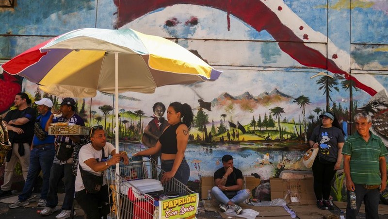 Seorang wanita melindungi putranya dari terik mentari dengan tas kardus saat gelombang panas melanda negara itu, di Vina del Mar, Cile, 19 Desember 2024. (REUTERS/Rodrigo Garrido)